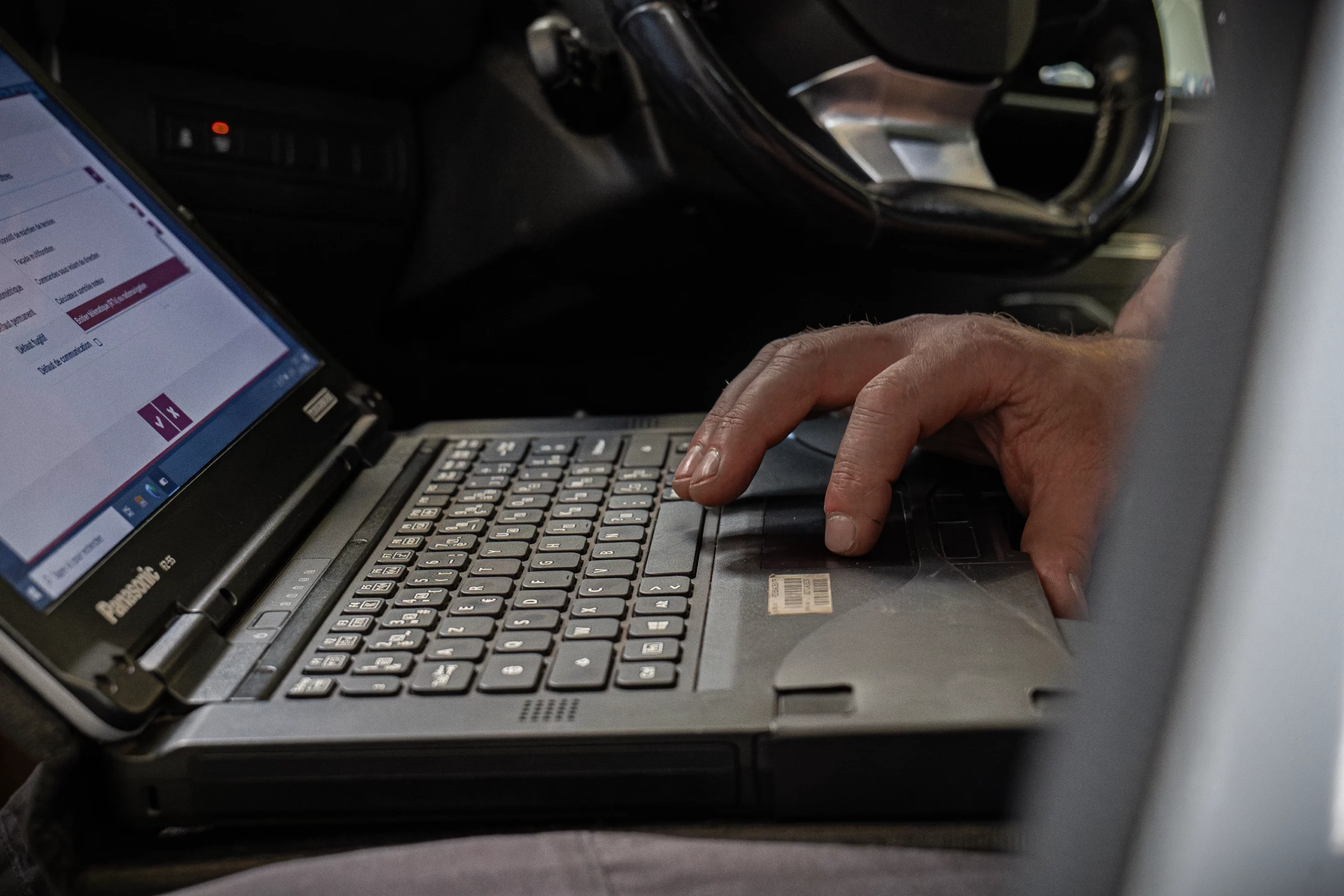 Technicien utilisant un ordinateur pour effectuer un diagnostic sur une voiture Peugeot.