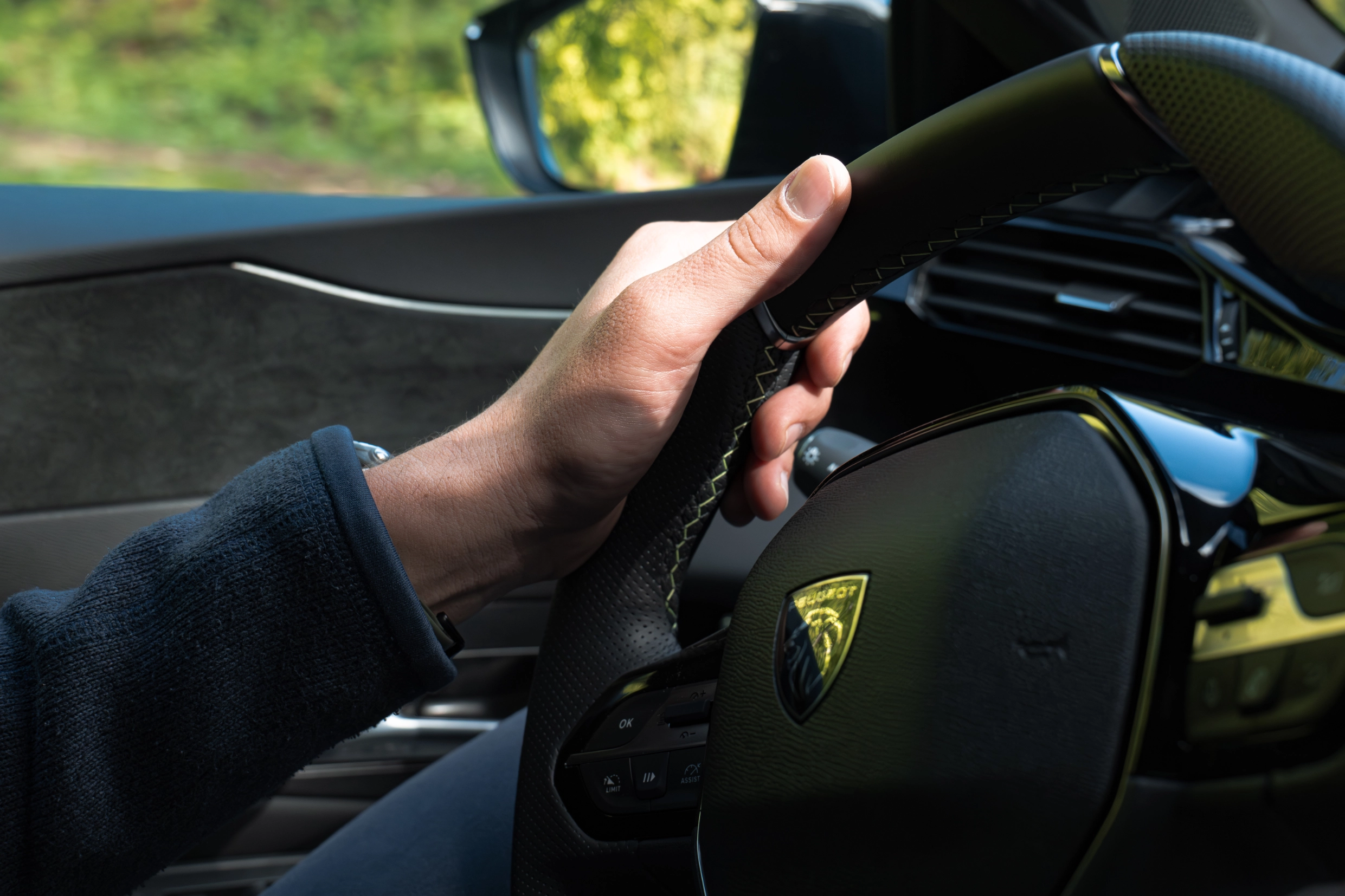 Volant d'une peugeot, quelqu'un conduit
